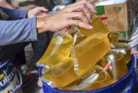 Pekerja mengemas minyak goreng curah di Pasar Subuh, Kabupaten Ciamis, Jawa Barat, Rabu (5/1/2022). Menko Bidang Perekonomian Airlangga Hartarto mengatakan pemerintah bekerja sama dengan Badan Pengelola Dana Perkebunan Kelapa Sawit (BPDPKS) akan menyediakan 1,2 miliar liter minyak goreng untuk masyarakat dengan harga jual Rp14 ribu per liter di tingkat konsumen di seluruh Indonesia selama enam bulan ke depan. ANTARA FOTO/Adeng Bustomi/wsj.