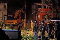 Rescue workers are seen at the site of a landslide in which a mother and six of her children were killed, in Paraty, Rio de Janeiro state, on April 2, 2022. - Torrential downpours triggered flash floods and landslides across Brazil's Rio de Janeiro state, killing at least 14 people including eight children, and leaving five missing, authorities said Saturday. (Photo by BRUNO KAIUCA / AFP)