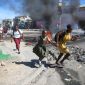 Seorang wanita dengan putrinya berjalan melewati barikade yang dipasang oleh anggota polisi saat demonstrasi pecah di Port-au-Prince, (AP PHOTO/ODELYN JOSEPH)